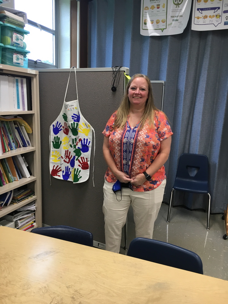 Clermont Northeastern Middle School teacher Cindy Dorsey stands near an apron with handprints of the first third-grade class she taught 26 years ago. Yeager is her maiden name. (Photo by Dick Maloney.)