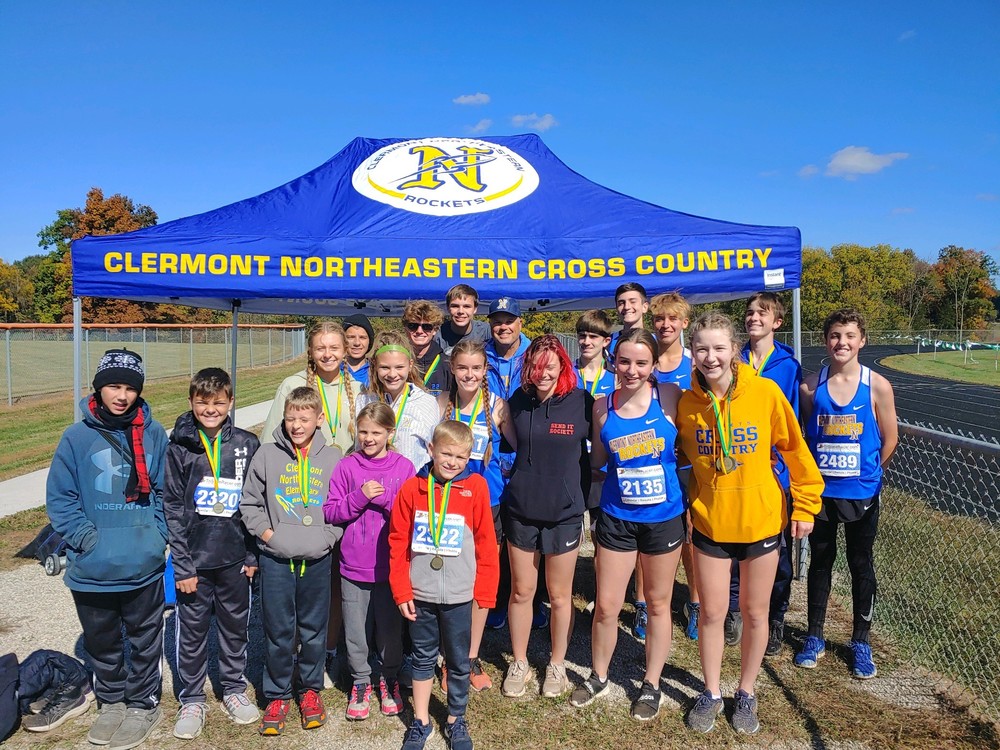 Clermont Northeastern’s cross country teams gather for a group photo after the Oct. 8 West Union meet. Sophomore Ellie Breitenstein won the girls race and senior Noah Bunting won the boys race. The boys also won the team title, while the girls placed second. (Photo courtesy Moe Cooper.)