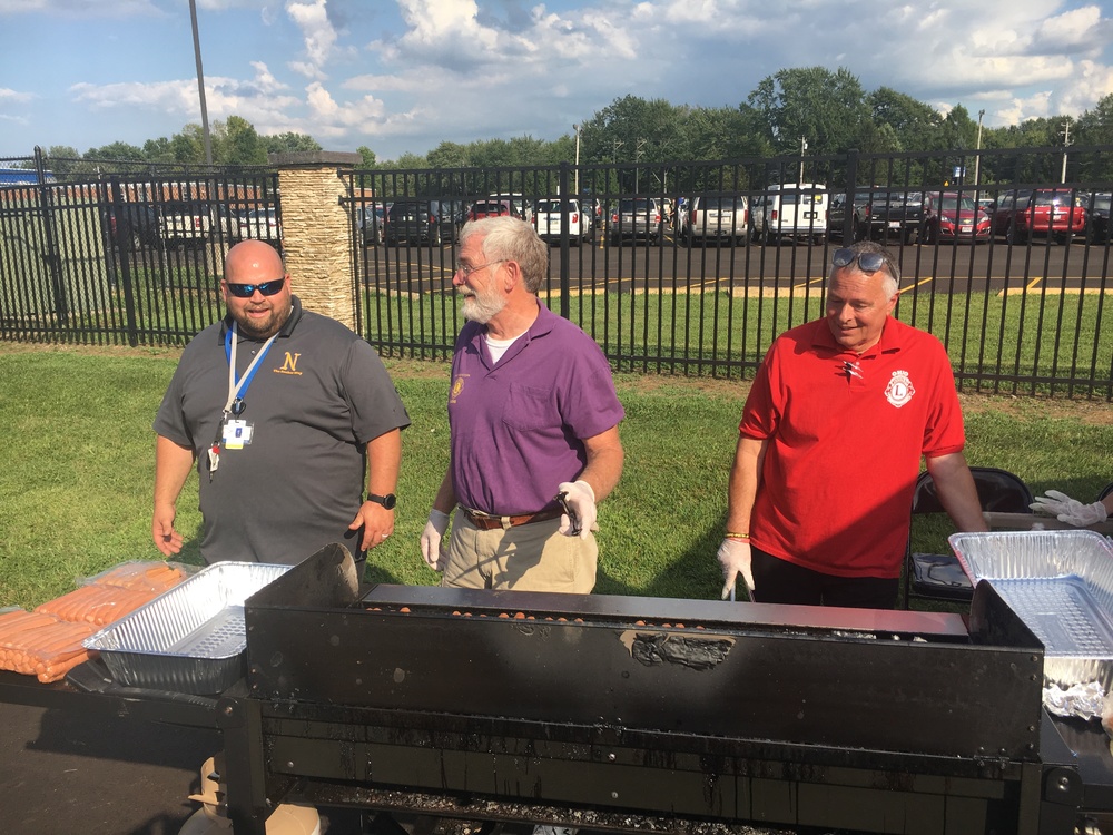 Clermont Northeastern Dean of Students T.J. Dorsey and Northeastern Lions Club members Tom Weiderhold and Brad Leigel work the grill at the CNE open house Aug. 15.